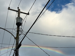 Un poteau électrique en ville et un arc-en-ciel, Québec, Canada. © Pascal Huot