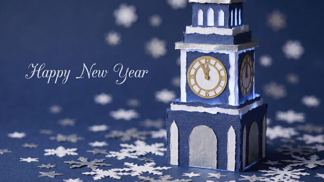 Festive Happy New Year celebration featuring a blue papercraft clock tower, snowflakes, and midnight countdown.