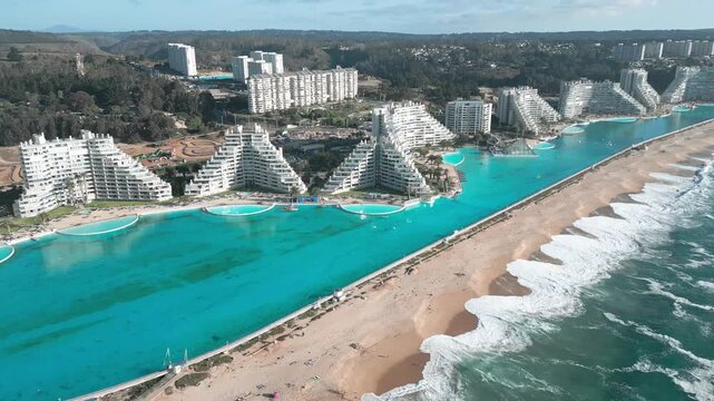 Aerial view of San Alfonso del Mar resort featuring its massive turquoise crystal lagoon, modern apartment buildings, and sandy beach in Algarrobo, Valparaiso, Chile.