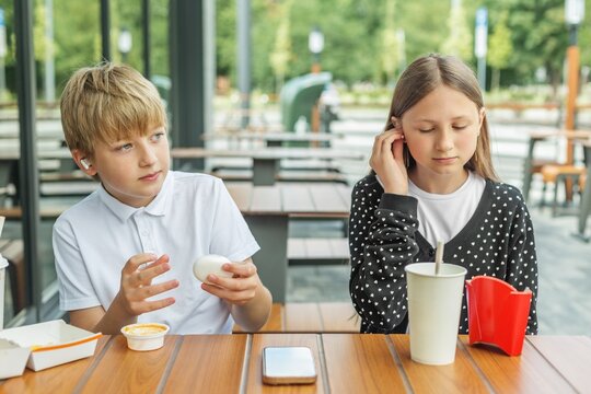 Friends using wireless earbuds together outdoors