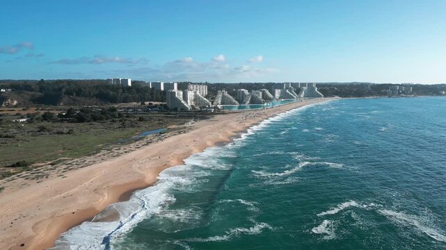 Aerial view of the San Alfonso del Mar resort complex along the coastline with sandy beach and turquoise ocean waves in Algarrobo, Valparaiso, Chile.