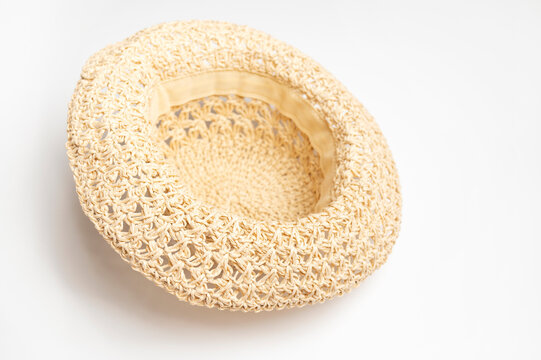 Straw panama hat on white background shows soft woven texture and relaxed shape. Neutral styling suits summer campaigns, travel content, accessory catalogs, retail layouts, and lifestyle branding.