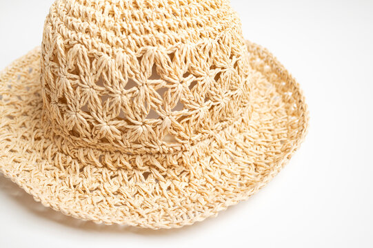 Straw panama hat fills close-up frame, showing woven fibers, wide brim, and textured crown on white background. Summer headwear suits beach fashion, travel marketing, and retail catalogs.