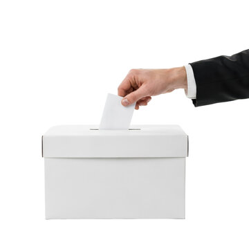 Hand in a black suit jacket sleeve inserting a white ballot paper into a plain white cardboard voting box isolated on a transparent background