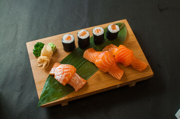 Fresh salmon sushi combo with nigiri and maki rolls on a wooden board  © younsse