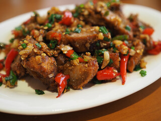 Fototapeta premium Stir-fried crispy pork with fresh chilies, garlic, and salt in a dish. It looks appetizing and tastes deliciously spicy.