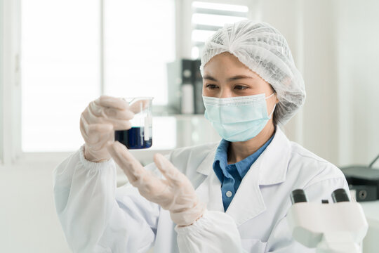 Female Laboratory Scientist Analyzing Samples with Pipette, Microscope and Laptop in Modern Research Laboratory