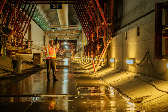 A construction white worker inspects an underground tunnel