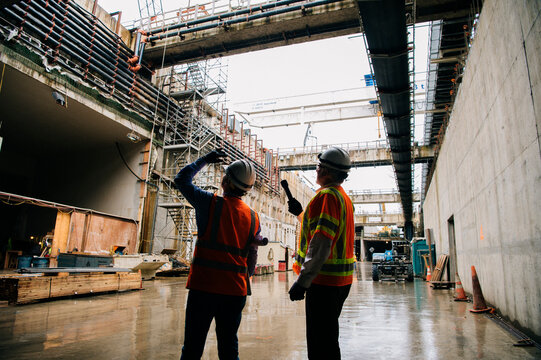 Two construction white workers discuss progress