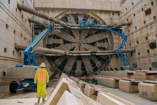 A construction white worker inspects a tunnel boring machine