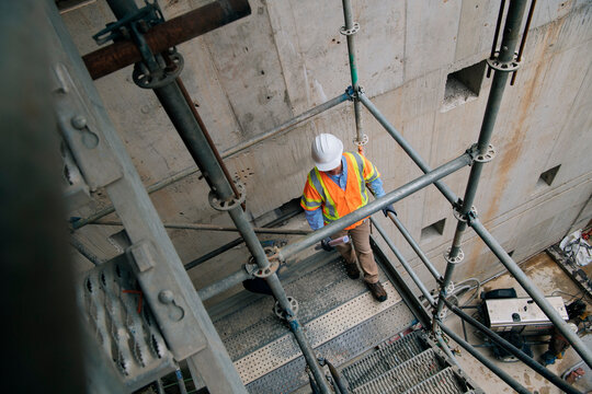 Two construction white workers communicate on scaffolding stairs