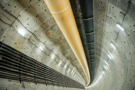 Inside a large round industrial tunnel with ventilation ducts