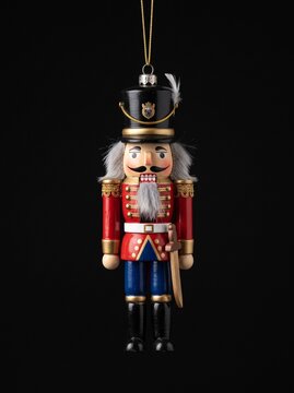 Vintage wooden nutcracker soldier Christmas tree ornament with sword isolated on black background