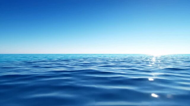 Calm blue ocean water surface with sun reflection and cloudless sky
