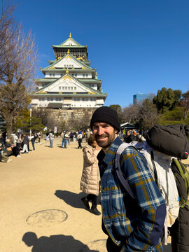Man smiling visiting Osaka Castle in Japan