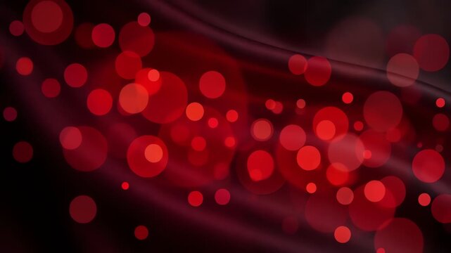 Abstract red bokeh lights glowing on dark wavy silk background