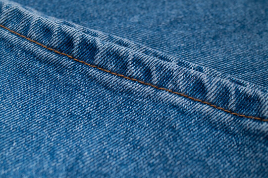 Blue jean pocket stitching creates textile detail across frame, with woven cotton surface visible in macro focus. Denim texture fits clothing promotion, craft content, fashion layouts, use.