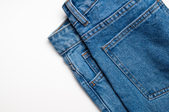 Blue jeans on white background show denim fabric, waistband, belt loops, seams, and rear pocket. Clean clothing presentation suits fashion retail, apparel catalogs, product design, and advertising.