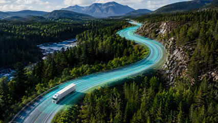 Fototapeta premium Aerial view of an autonomous semi truck driving along a winding mountain highway through dense evergreen forest with glowing digital sensor lanes illustrating connected logistics and intelligent trans
