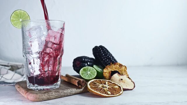 Pouring Peruvian Chicha Morada, Purple Corn Drink with Lime and Cinnamon