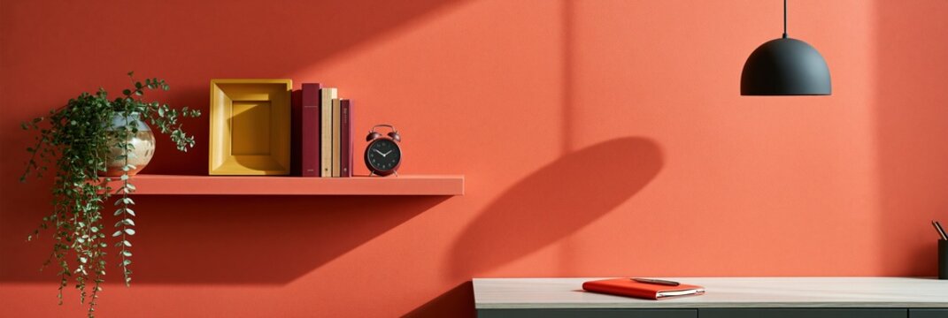 Modern workspace with red accent wall, floating shelf, pendant lamp and orange notebook for office background and banner design