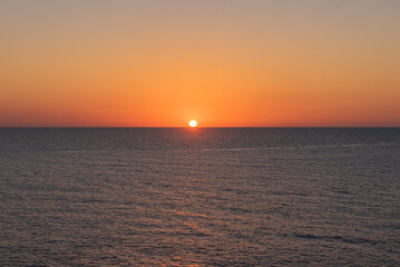 Obraz premium The still ocean at dawn or dusk, with calm, peaceful waters.