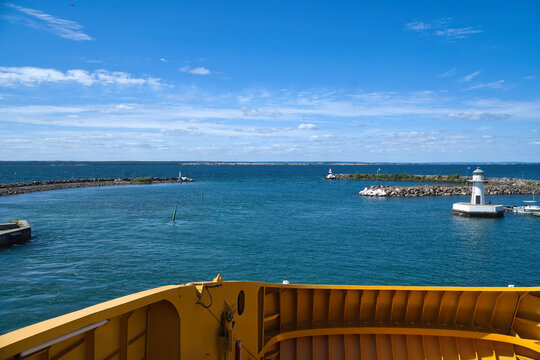 View from Ship Deck onto Harbor Entrance with Lighthouse in Sunlight