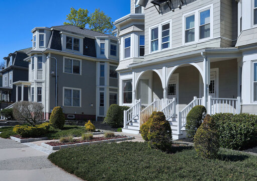 Street of three story semi-detached clapboard houses with dormer windows