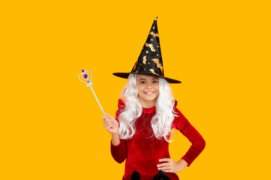 Girl in witch costume hold magic wand. Happy Halloween. Girl witch in Halloween costume isolated on yellow. Trick or treat. Halloween costume party. All Hallows witch girl