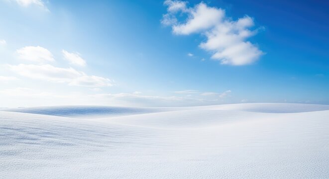 Pristine white snow covers a rolling winter field under a vibrant blue sky filled with soft white clouds, creating a peaceful scene, white, wintertime, tranquility