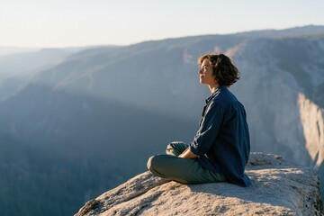 Fototapeta premium Woman meditating on cliff edge at mountain sunrise for mindfulness and nature wellness background suitable for meditation retreat or wallpaper