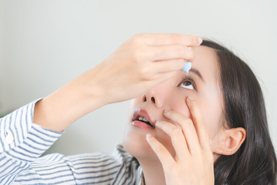 Health care concept, eye problem asian young woman applying, using medical eye drops to treat dry eye and irritation, suffering from irritated eye dry eyes or inflammation, allergy optical symptom.