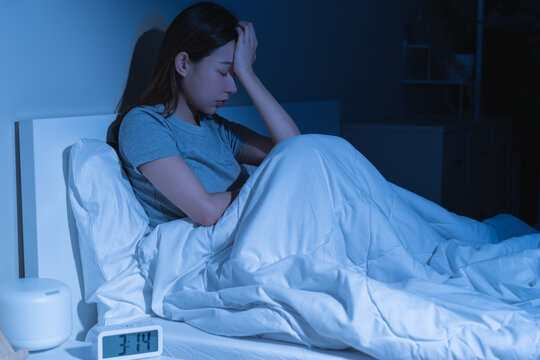 Sad worried and stressed, depressed asian young woman, girl suffering in bed from insomnia problem, awake at night, hand covering face from trouble disturbed loud noise, unable sleep. Restless people.