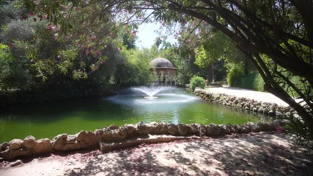 View of fountain and pond in Parque de Mari&shy;a Luisa on a sunny day, Seville, Andalusia, Spain