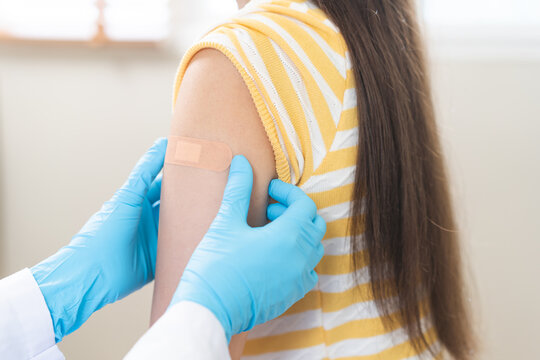 Vaccination coronavirus, hand of doctor apply plaster, bandage after doctor giving vaccine, injection dose on arm patient, immunization disease prevention against flu pandemic influenza, health care.