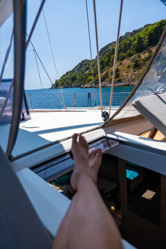 Relaxing on a sailing yacht with scenic coastal view from the cockpit. Slow living and freedom while traveling by sea.