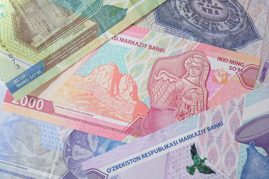Close up of colorful Uzbekistani som banknotes featuring historical landmarks