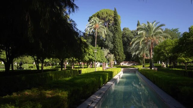 View of trees and fountain in Parque de Mari&shy;a Luisa on a sunny day in Seville Seville, Andalusia, Spain