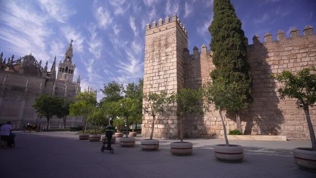 View of Cathedral of Seville and Puerta del Leon, entrance of Royal Alcazar of Seville on a sunny day, Sevilla, Andalusia, Spain