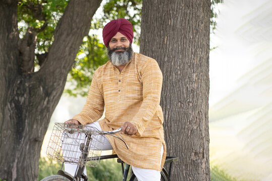 Indian happy punjabi sikh sardar riding cycle at village