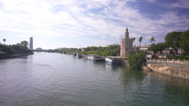 View of Canal de Alfonso XIII river and Torre del Oro (the Golden Tower) on a sunny day, Seville, Andalusia, Spain