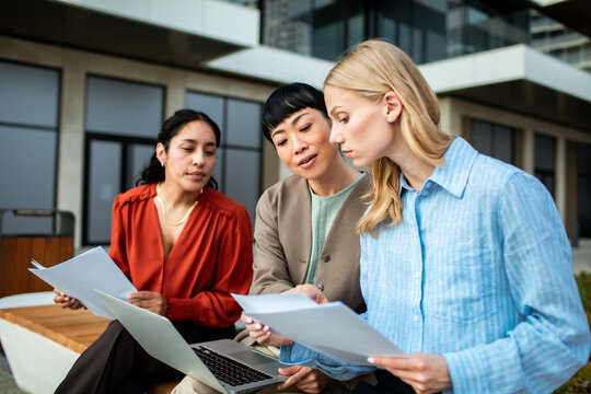 Three colleagues reviewing documents outside the office