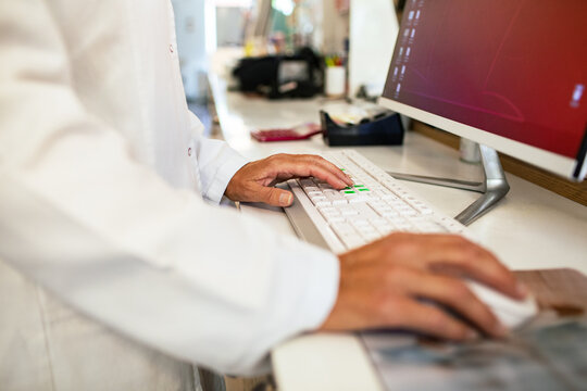 Pharmacist using computer at pharmacy counter