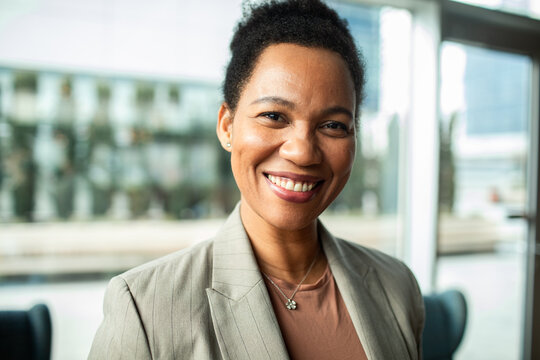 Confident businesswoman smiling portrait in modern office