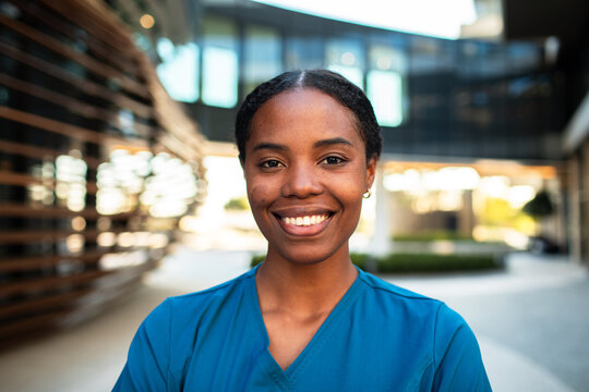 Smiling healthcare worker portrait outside modern clinic