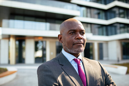 Confident business executive standing outside modern office building