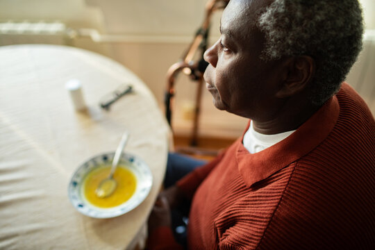 Senior man with soup at home kitchen table