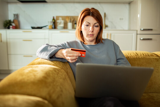 Woman shopping online with credit card at home