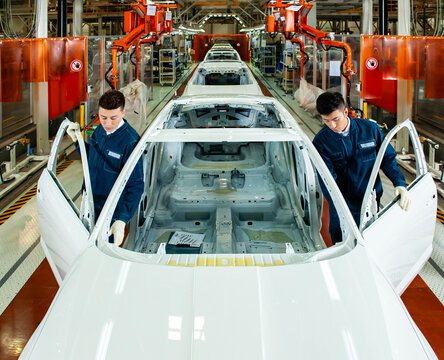 Automobile Assembly Line Workers Inspecting Unfinished Car Body in Modern Automotive Manufacturing Factory