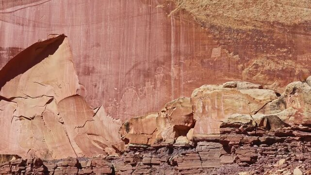 Ancient Fremont Culture petroglyphs showing anthropomorphic figures and animals etched into sandstone walls at Capitol Reef National Park Utah